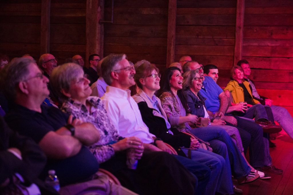 An amused audience watches a show at The Barns. 